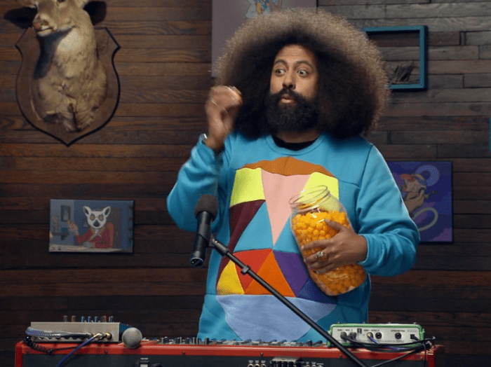 REggie wears a sweater that kind of looks like a mini vest on the shirt